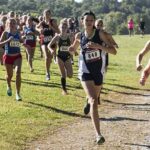 Community Pressure Forces 5K Event To Move women cross-country runners racing on a grassy trail