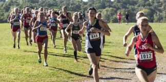 women cross-country runners racing on a grassy trail