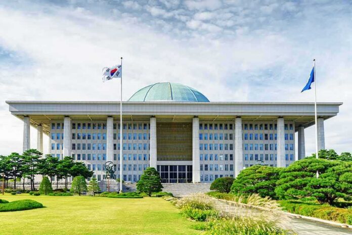 Parliament building with a green dome and flagpoles