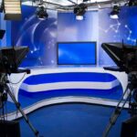 Fox Business Host Exits After More Than 12 Years A television studio setup with cameras and a blue backdrop