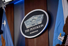 Military Execution Approved After 65 Years The Pentagon emblem between two flags.