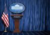 Trump Vows to Stop Iran’s Nuclear Ambitions White House press briefing podium with U.S. flag and blue curtain