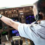 Pilot adjusting controls in an airplane cockpit