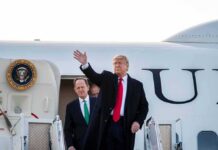 Donald Trump waves from aircraft steps with Patrick Joseph Toomey behind him