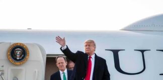 Donald Trump waves from aircraft steps with Patrick Joseph Toomey behind him