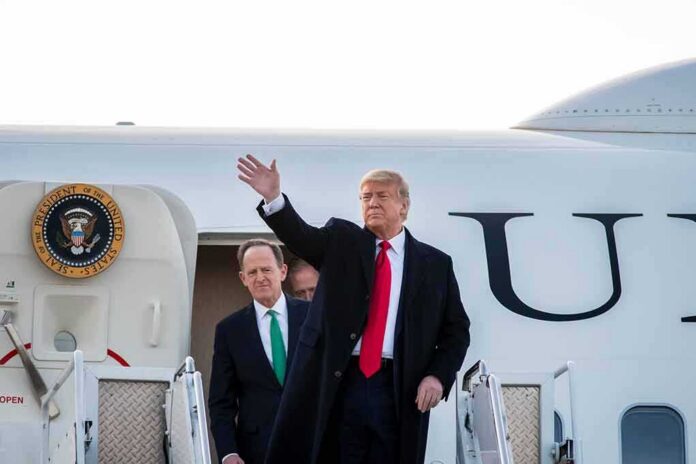 shutterstock_1666020424 Donald Trump waves from aircraft steps with Patrick Joseph Toomey behind him