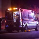 Ambulance at night with paramedics attending a patient