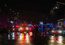 Porch Collapse Injures 28 at College Party Nighttime police scene with flashing lights on a wet city street