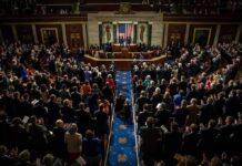 Election Rules Spark New Political Clash Legislative chamber audience stands and applauds