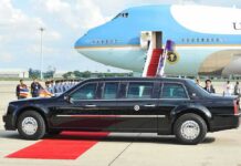 Presidential limousine beside a large blue-and-white jet on a runway