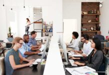 Office workers at shared desks using desktop computers