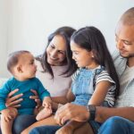 Brother Says Trump Politics Drove Siblings Apart Family sitting on couch with parents, daughter, and baby smiling together